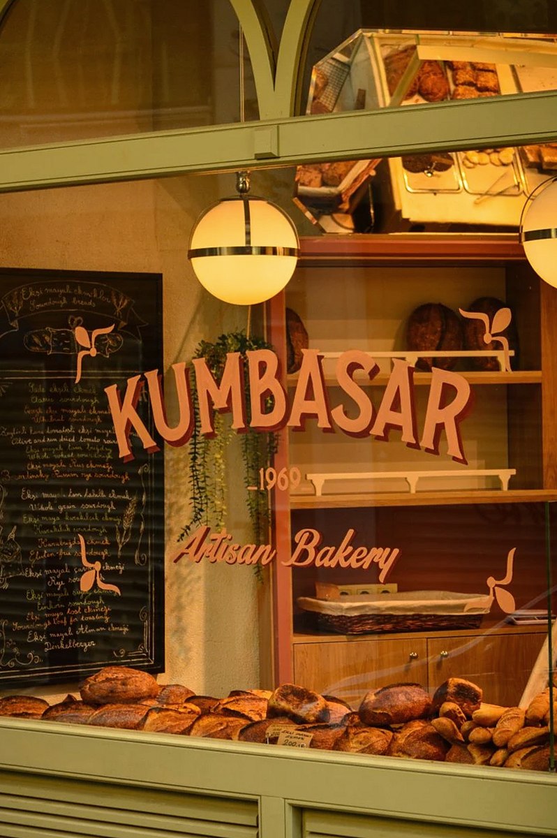 A cozy artisan bakery displaying a variety of fresh bread loaves through a window.